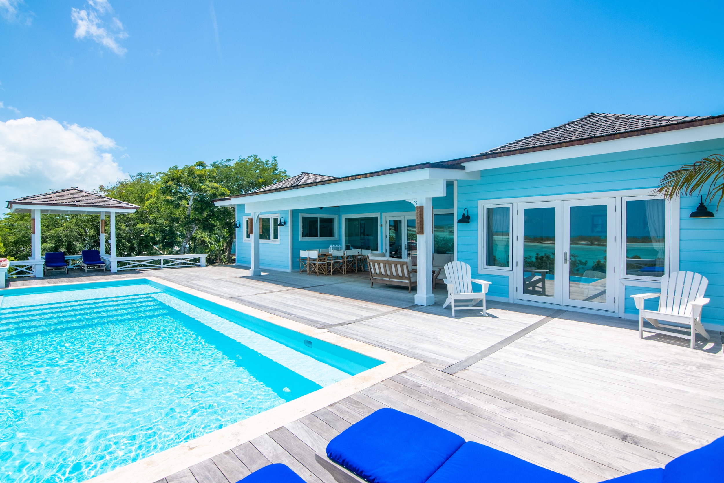 amani house bahamas sunny day view of house behind pool